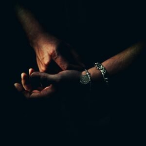 Intriguing close-up of hands with bracelets captured in dramatic lighting.